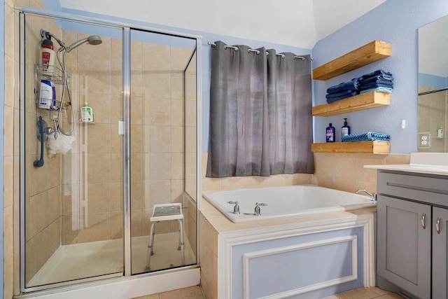 bathroom with tile patterned flooring, vanity, and separate shower and tub