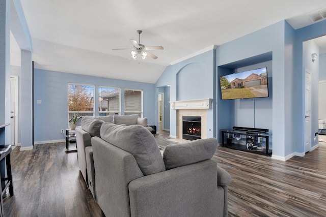 living room featuring lofted ceiling, a tiled fireplace, ceiling fan, and dark hardwood / wood-style floors