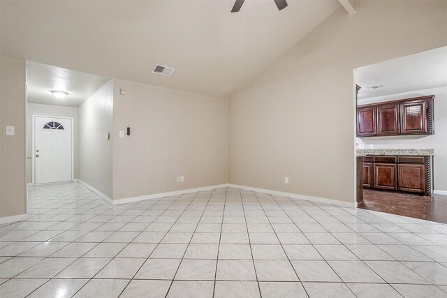 unfurnished living room featuring vaulted ceiling with beams, ceiling fan, and light tile patterned floors