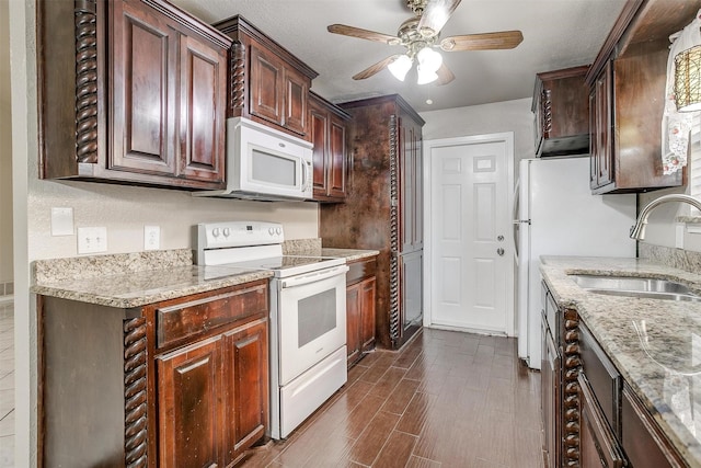 kitchen with light stone counters, sink, ceiling fan, and white appliances