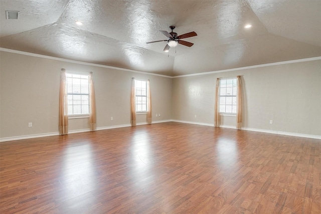 spare room with lofted ceiling, crown molding, hardwood / wood-style flooring, ceiling fan, and a textured ceiling