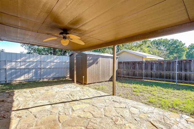 view of patio with ceiling fan and a shed