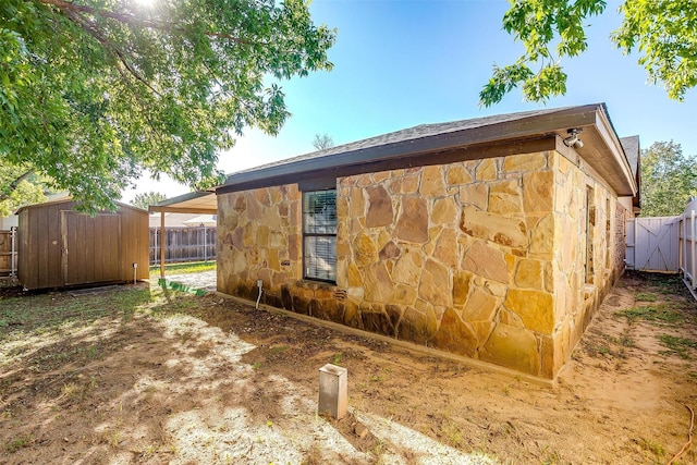 view of side of home with a shed