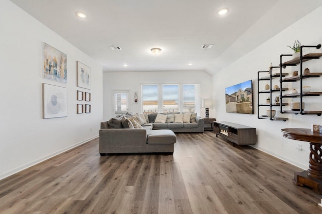 living room featuring hardwood / wood-style flooring and vaulted ceiling