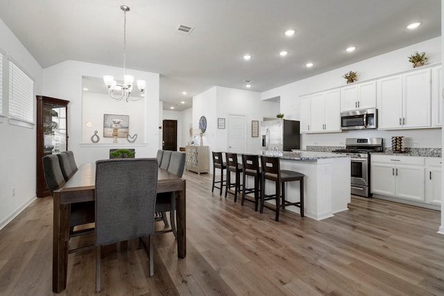 dining area with wood-type flooring and a chandelier