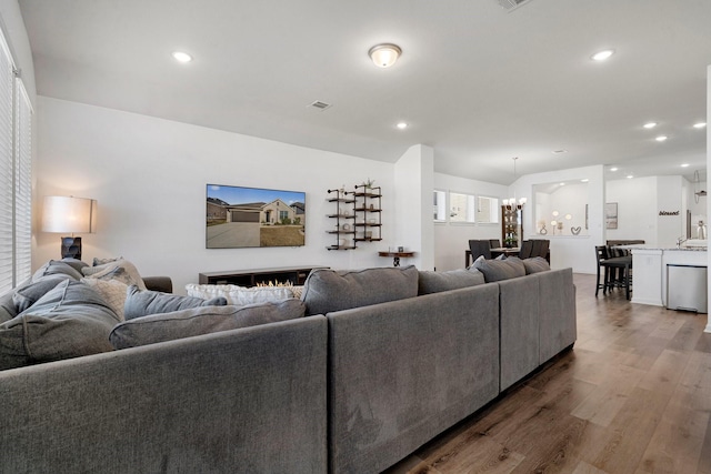 living room with dark hardwood / wood-style flooring and an inviting chandelier