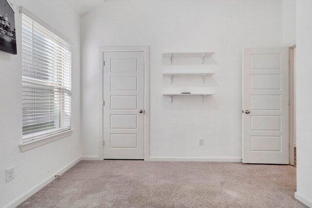 unfurnished room featuring light carpet