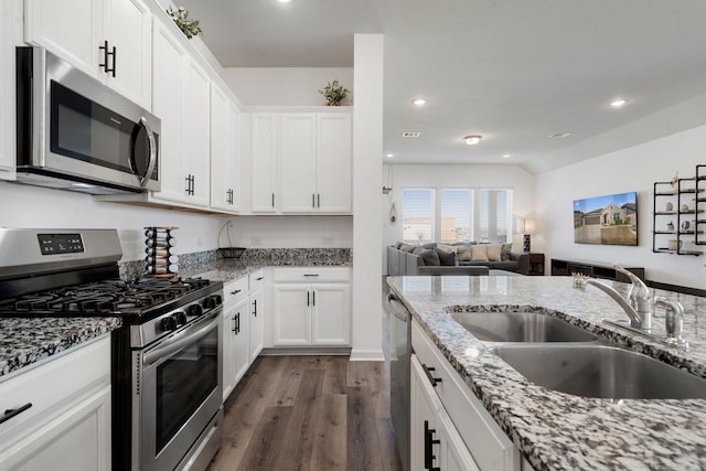 kitchen featuring light stone countertops, stainless steel appliances, white cabinetry, and sink