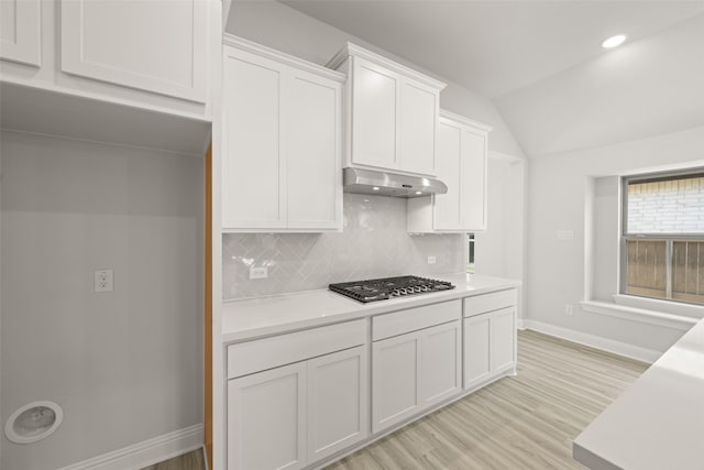 2009 Elm Pl, Northlake, TX 76247 - kitchen featuring stainless steel gas cooktop, extractor fan, light countertops, white cabinets, and vaulted ceiling