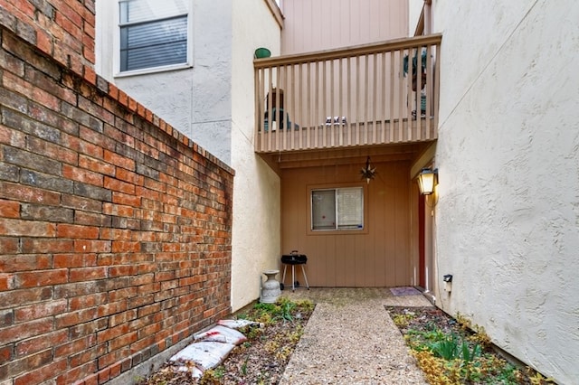 view of exterior entry featuring a balcony