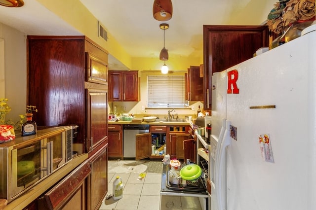 kitchen with stainless steel dishwasher, sink, light tile patterned floors, white fridge, and hanging light fixtures