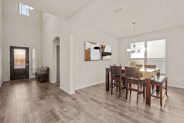 dining area featuring plenty of natural light, an inviting chandelier, and light hardwood / wood-style flooring