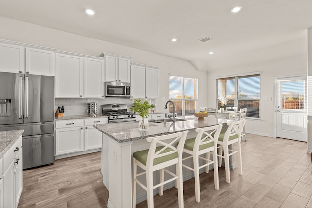 kitchen featuring light stone counters, white cabinetry, sink, and appliances with stainless steel finishes