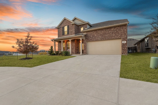 view of front of property featuring a lawn, a porch, and a garage