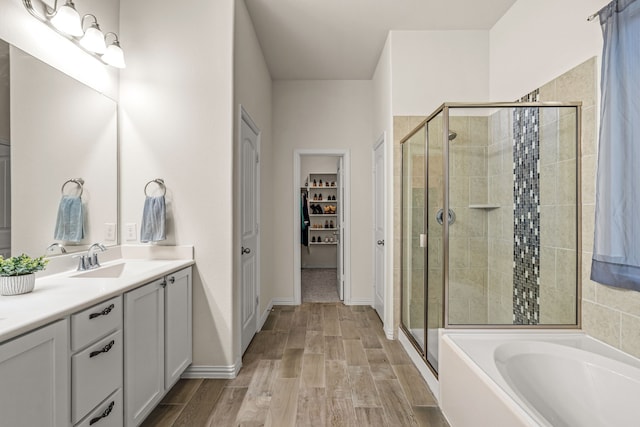 bathroom featuring hardwood / wood-style flooring, vanity, and shower with separate bathtub