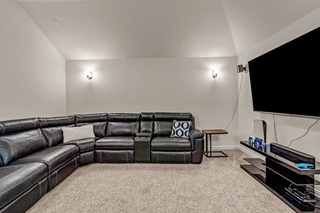 cinema room with carpet flooring and vaulted ceiling