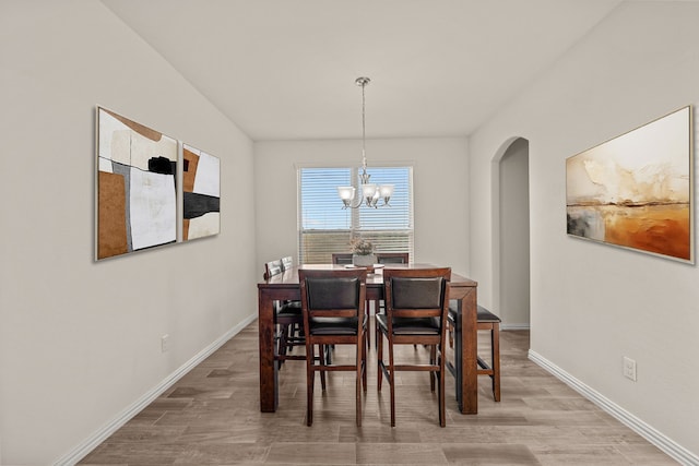 dining room featuring wood-type flooring and an inviting chandelier