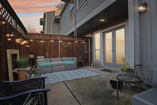 patio terrace at dusk with french doors and an outdoor hangout area