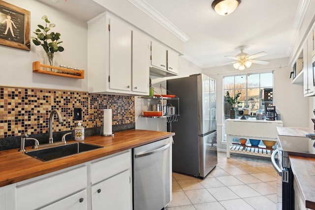 kitchen featuring appliances with stainless steel finishes, ceiling fan, crown molding, sink, and white cabinetry