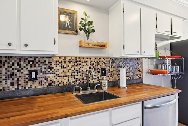 kitchen with butcher block countertops, decorative backsplash, white cabinetry, and sink