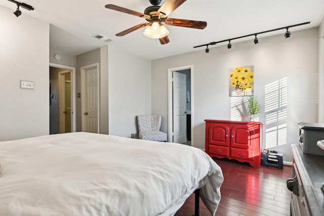 bedroom featuring ceiling fan, dark hardwood / wood-style floors, and track lighting