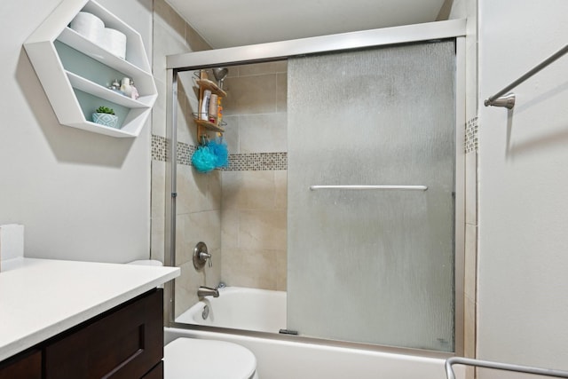 full bathroom featuring combined bath / shower with glass door, vanity, and toilet