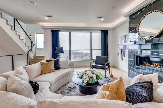 living room with a premium fireplace and light hardwood / wood-style flooring