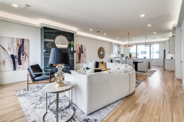 living room with a notable chandelier and light wood-type flooring