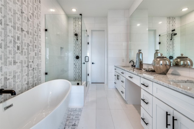 bathroom with tile patterned flooring, vanity, separate shower and tub, and tile walls