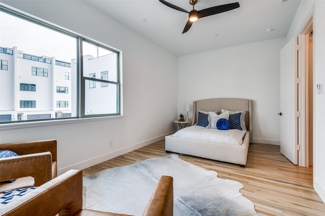 bedroom featuring multiple windows, ceiling fan, and light hardwood / wood-style floors