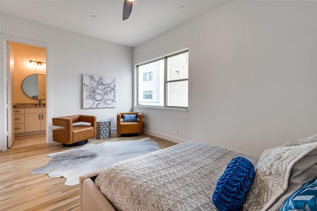 bedroom with ceiling fan, light hardwood / wood-style floors, sink, and connected bathroom