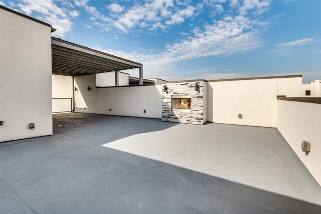 view of patio featuring a carport and a fireplace