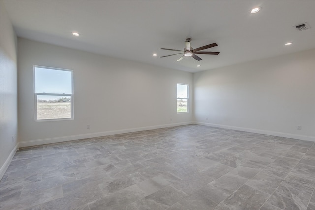 unfurnished room featuring ceiling fan and a wealth of natural light