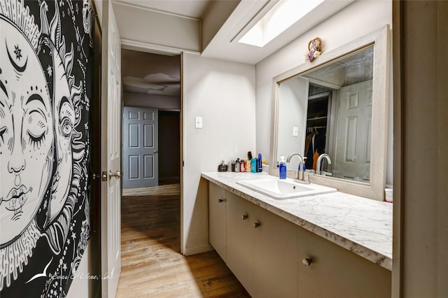 bathroom featuring a skylight, vanity, and hardwood / wood-style flooring