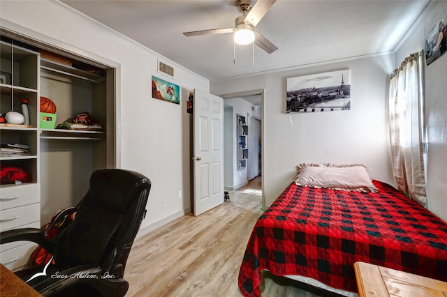 bedroom with ceiling fan, ornamental molding, light hardwood / wood-style flooring, and a closet