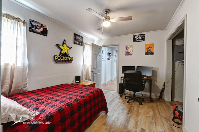 bedroom with ceiling fan, light hardwood / wood-style floors, ornamental molding, and multiple windows