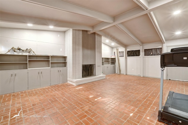 workout room featuring a fireplace and vaulted ceiling