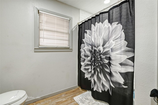 bathroom featuring a shower with curtain, toilet, and hardwood / wood-style floors