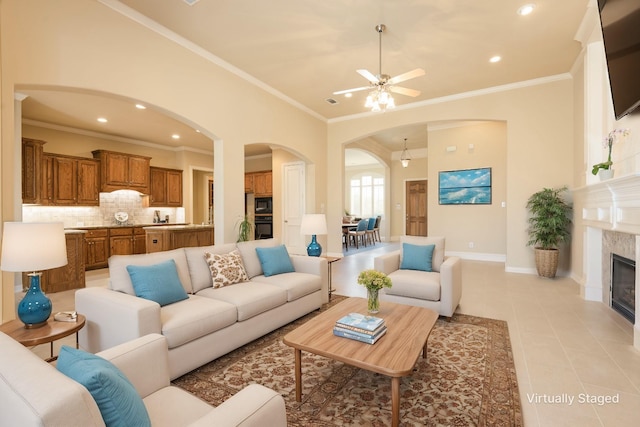 living area featuring light tile patterned floors, recessed lighting, a fireplace, baseboards, and ornamental molding