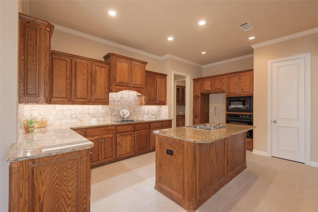 kitchen featuring light stone counters, brown cabinets, visible vents, a sink, and black appliances