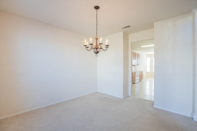 carpeted empty room with a chandelier