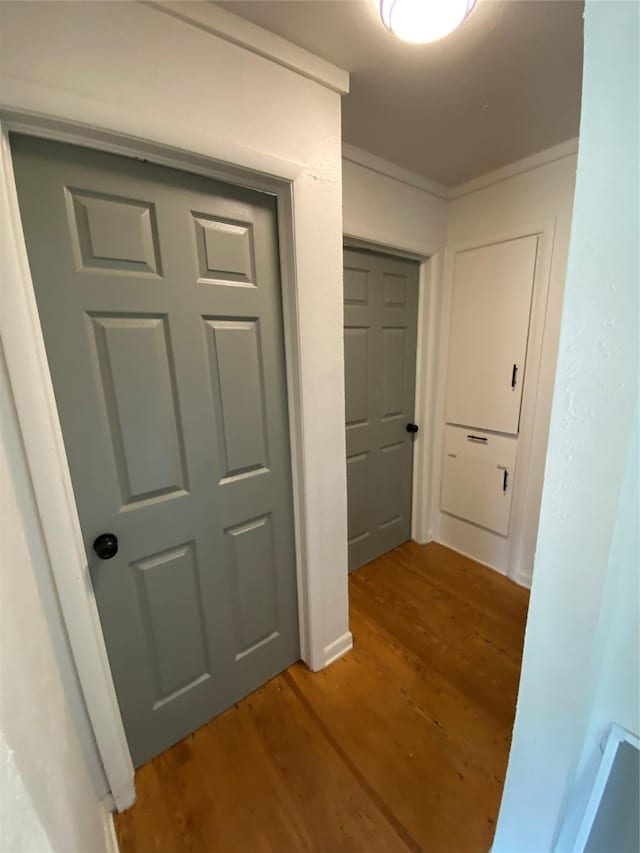 corridor with crown molding and hardwood / wood-style flooring