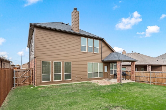 rear view of property with a yard and a patio area