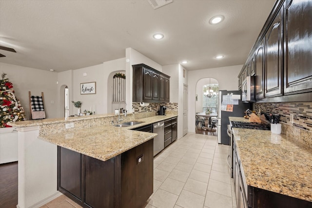 kitchen featuring decorative backsplash, kitchen peninsula, and sink