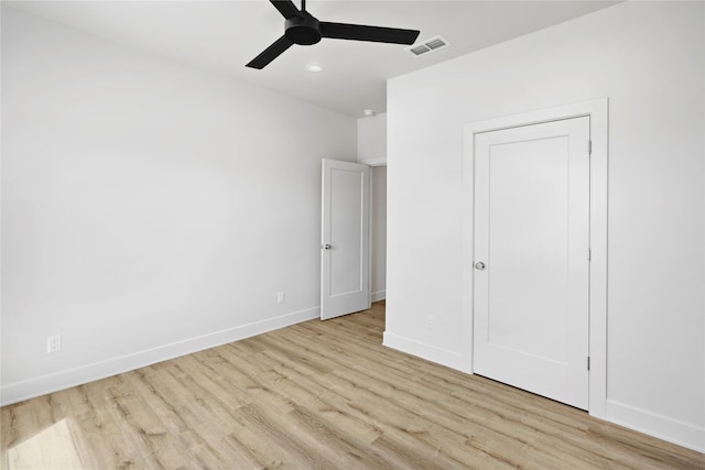 unfurnished bedroom with a closet, light hardwood / wood-style floors, and ceiling fan