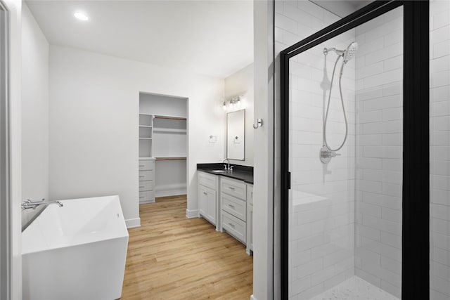 bathroom with vanity, a shower with shower door, and wood-type flooring