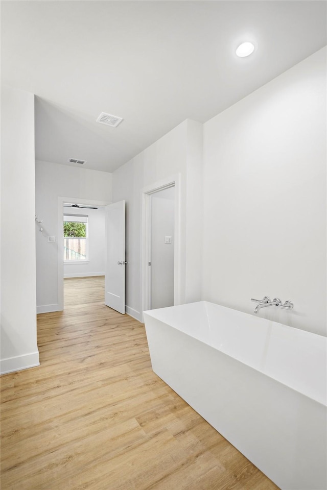 bathroom featuring a bath and wood-type flooring