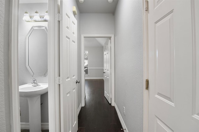 hall with dark wood-type flooring and sink