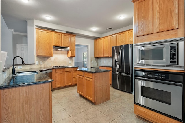 kitchen featuring sink, a center island, appliances with stainless steel finishes, kitchen peninsula, and dark stone counters