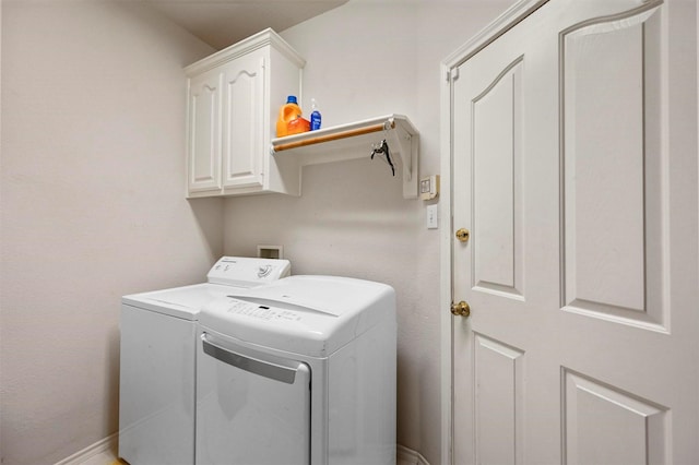 washroom with cabinets and washer and dryer